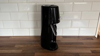The side view of the Sodastream Spirit One Touch without a bottle inserted on a kitchen countertop