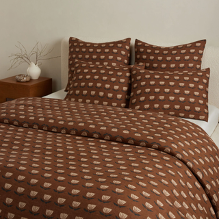 brown duvet and four pillows with floral motif