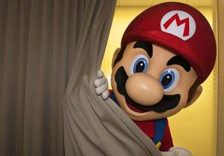 A photo shows a Mario costume character peering out from behind a gray curtain.