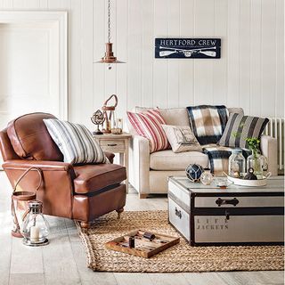 living room with white wall brown and cream colour sofa chair with cushion