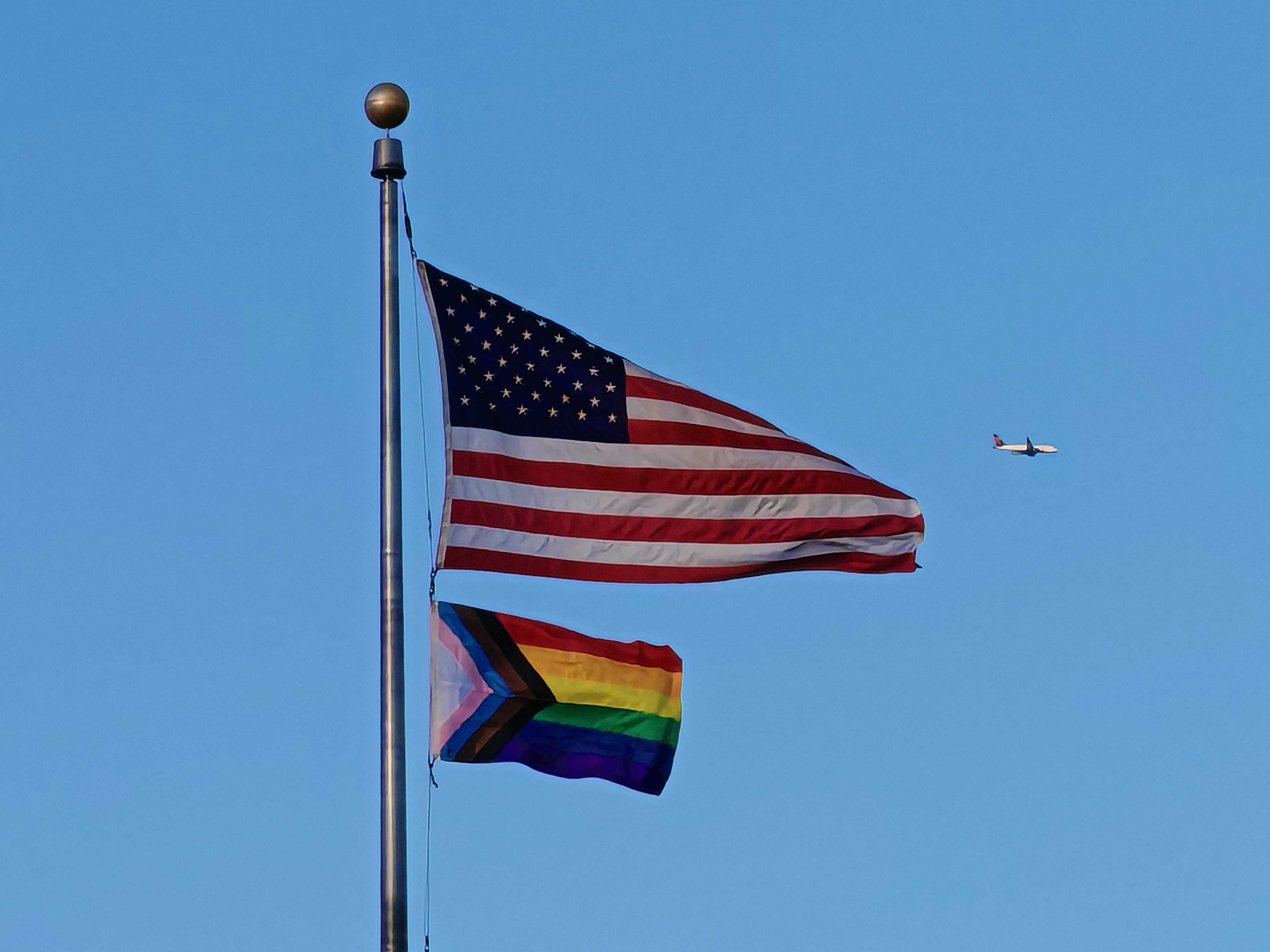 Flags with an airplane in the background