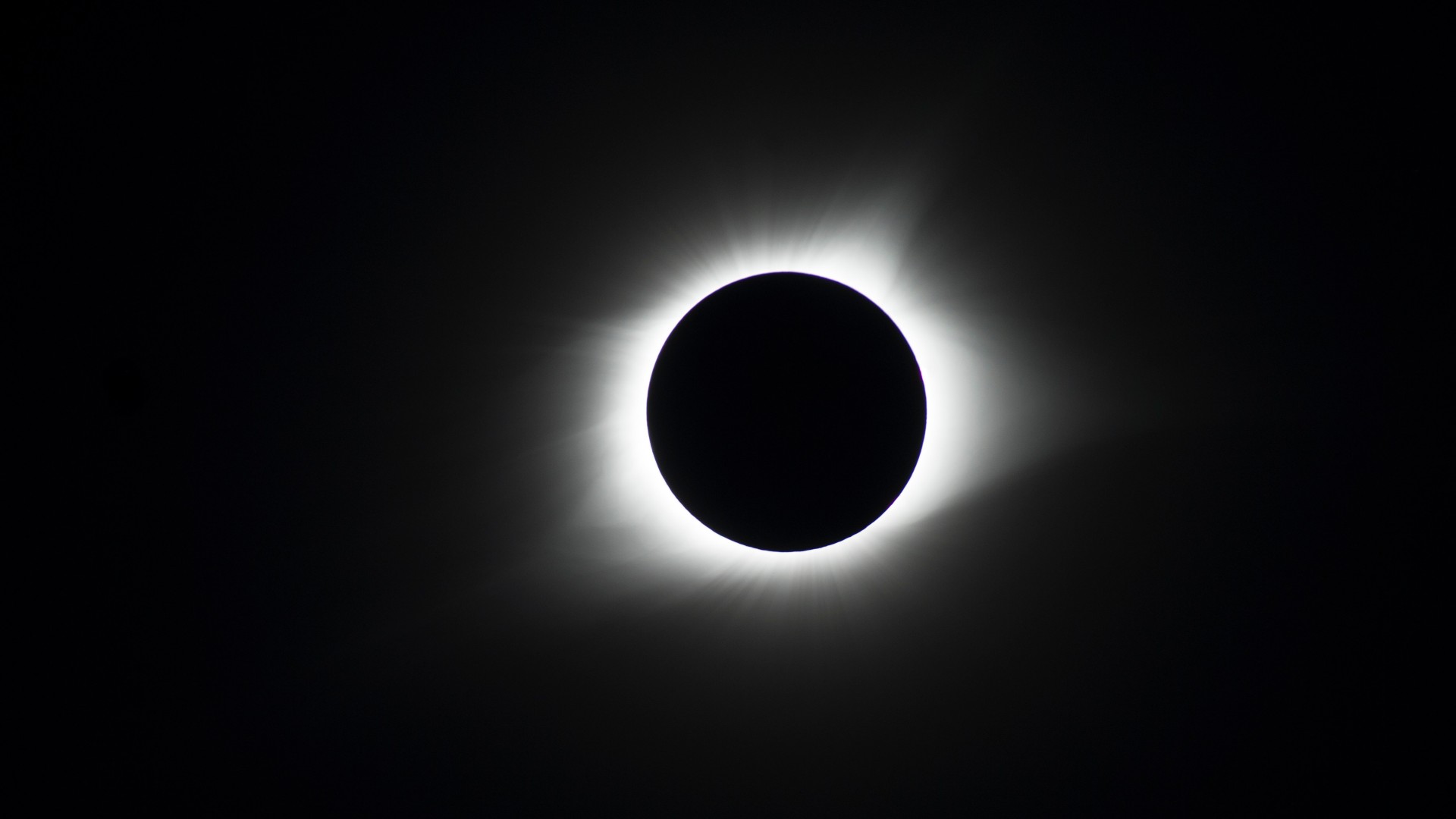 Total solar eclipse on August 21, 2017. Here we see a black circle (moon) surrounded by a circle of white light (sun), all against a black background.