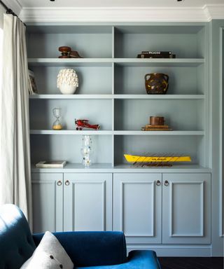 Living room detail with fitted light grey cabinet in alcove.