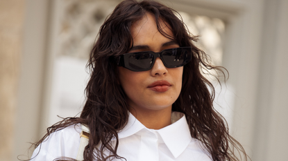 woman with wavy hair and sunglasses wearing a white shirt - best Mattifying primer