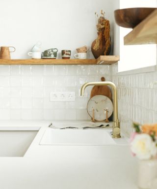 An image of a kitchen with white countertops with wooden cabinets