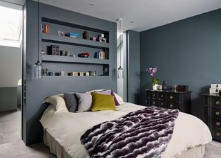 bedroom with grey walls, clever storage and colourful cushions