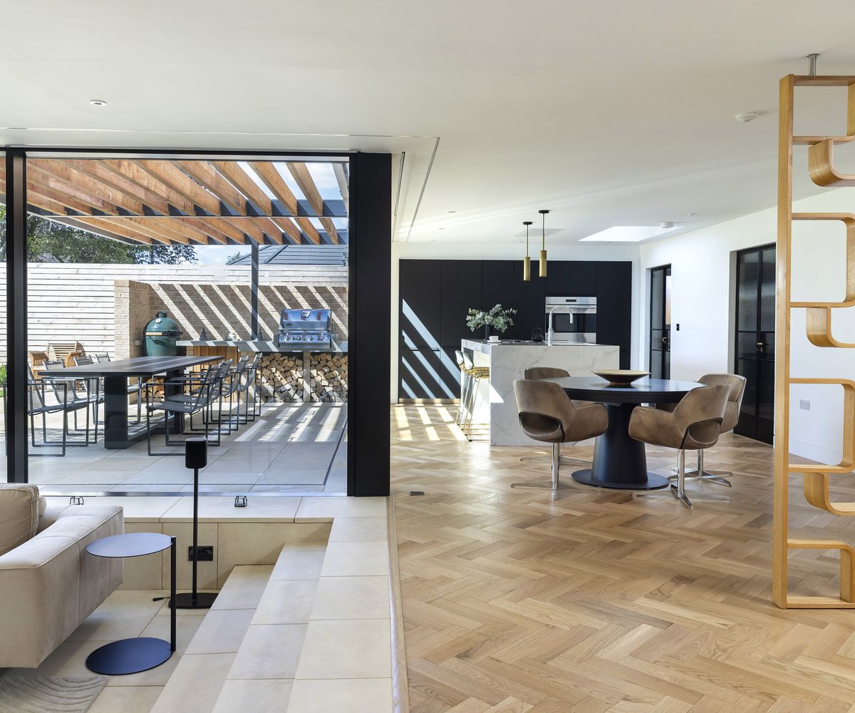 Sunken seating area next to a kitchen and dining area with views to a covered patio