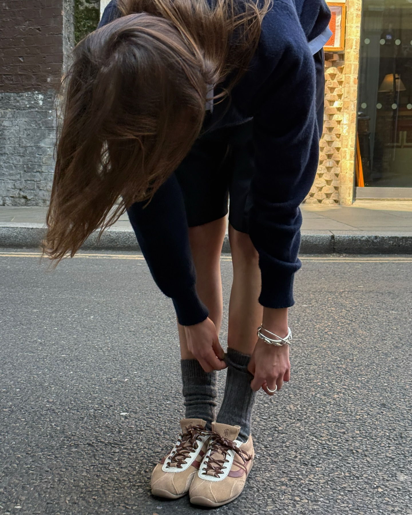 An image of @poppyalmond wearing brown suede retro trainers.