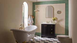 traditional bathroom with green tiled border and rolltop bath