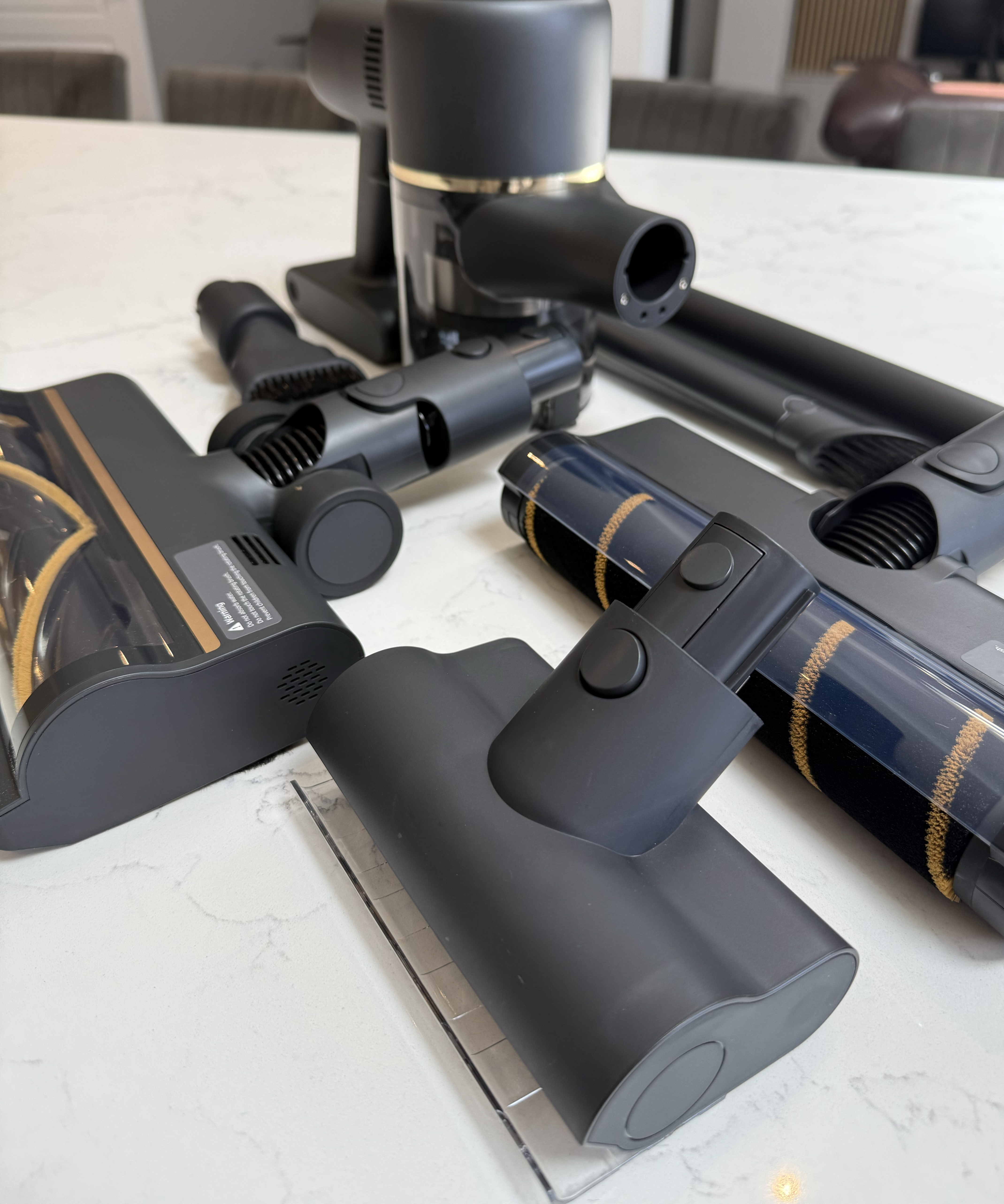 Dreame R10 Pro cordless vacuum attachments laid out on a marble-effect kitchen countertop