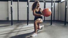 Young woman exercising with medicine ball in gym