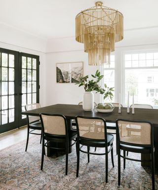 Black dining table, white vase, black framed glass doors