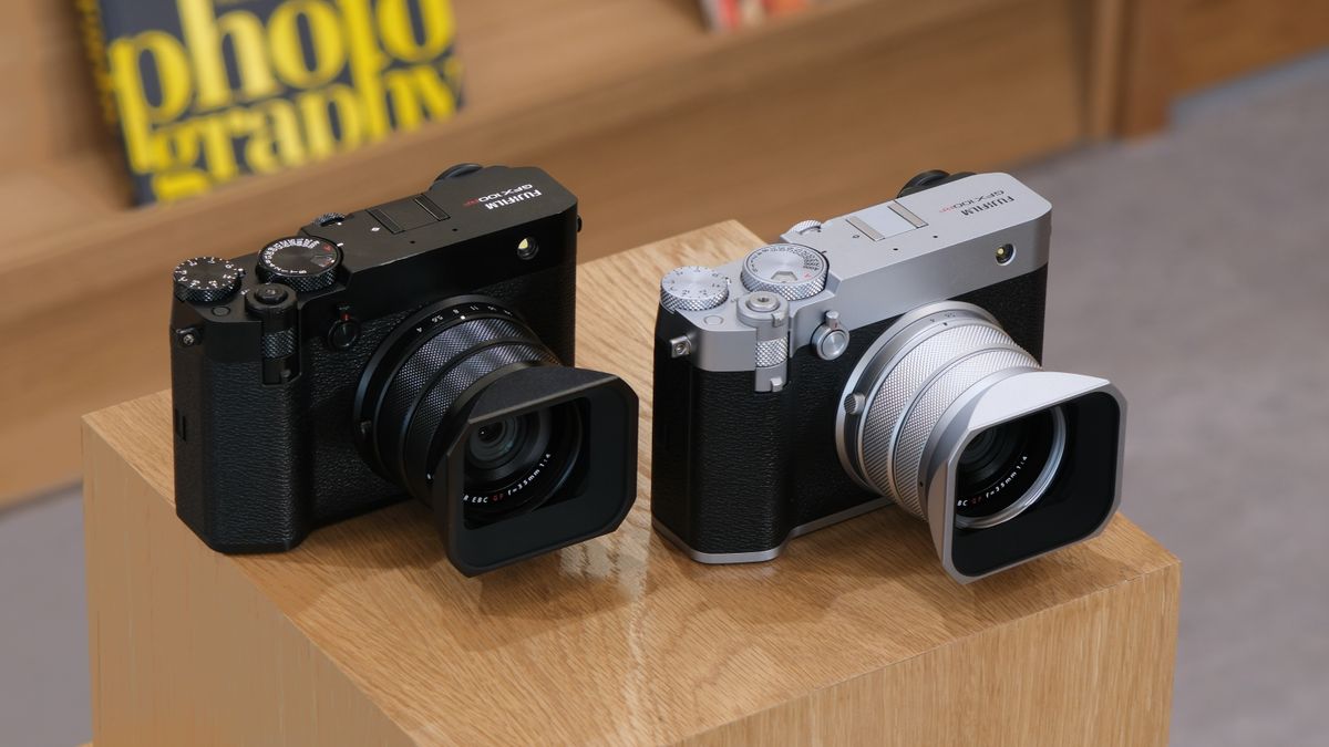 Two Fujifilm GFX 100RF cameras in silver and black on a wooden plinth