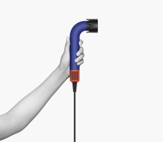 Dyson Supersonic r hair dryer held up by a hand