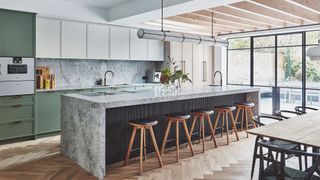large open plan kitchen diner with full height glazing and louvred ceiling