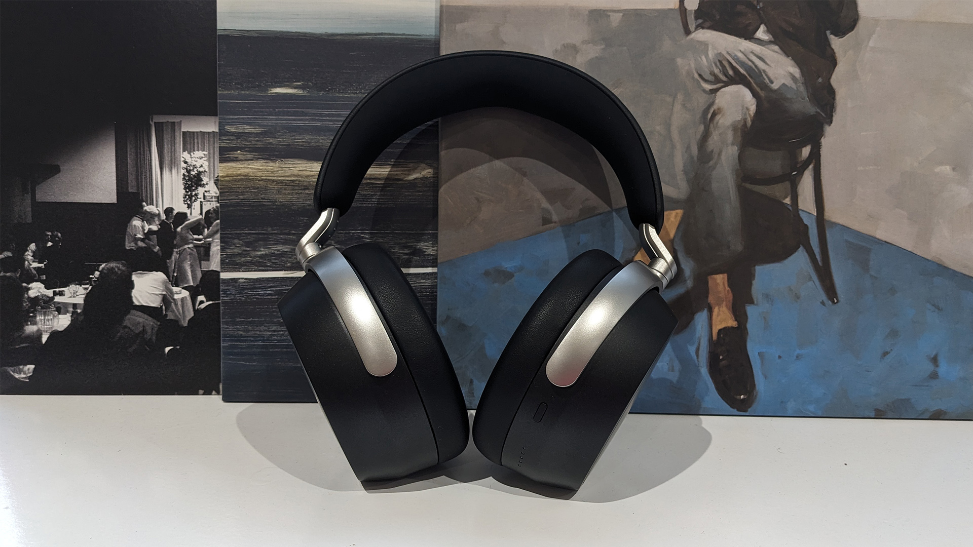 Sennheiser HDB 630 over-ear headphones on white shelf in front of pictures