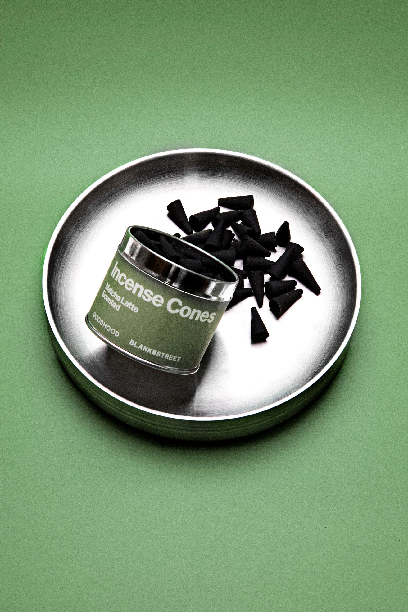 A silver plate with black matcha latte incense cones