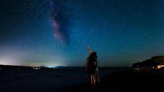 silhouettes of two children looking up at the night sky