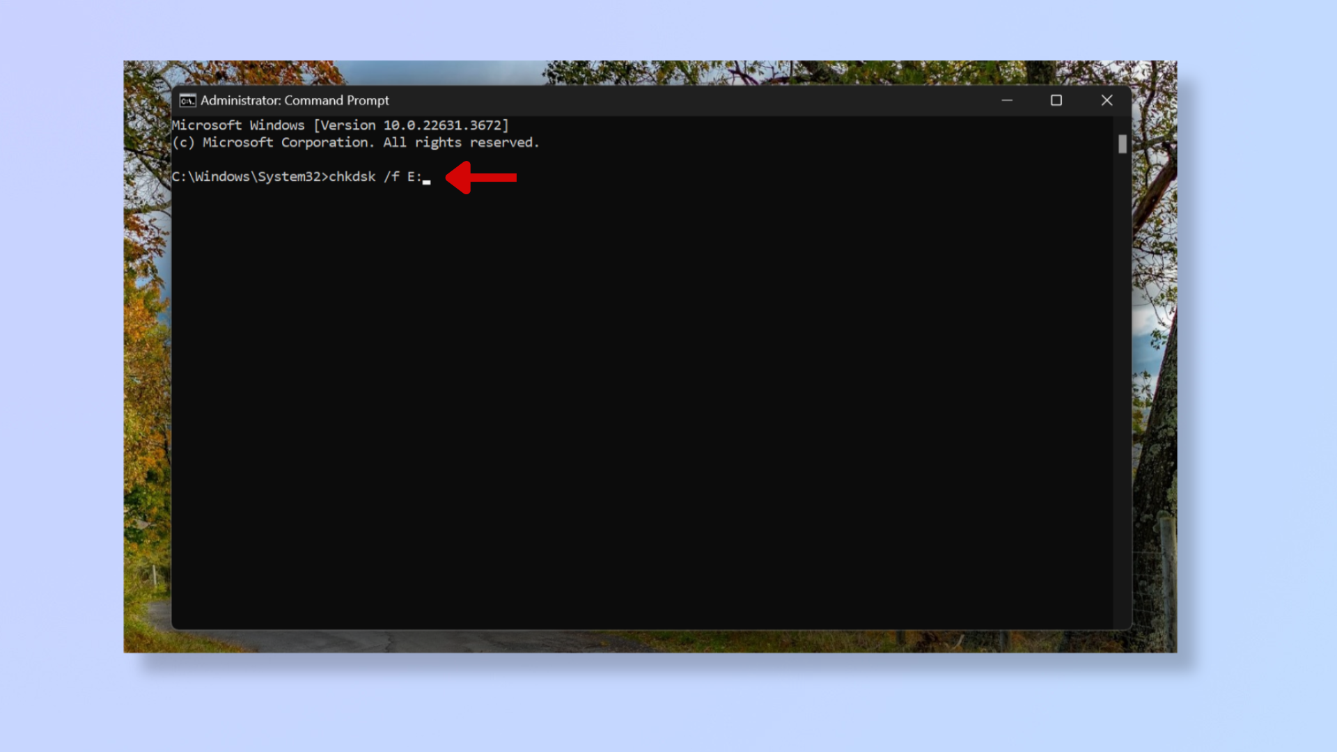 A screenshot of the Command Prompt tool on Windows with a red arrow pointing at chkdsk /f E:. 