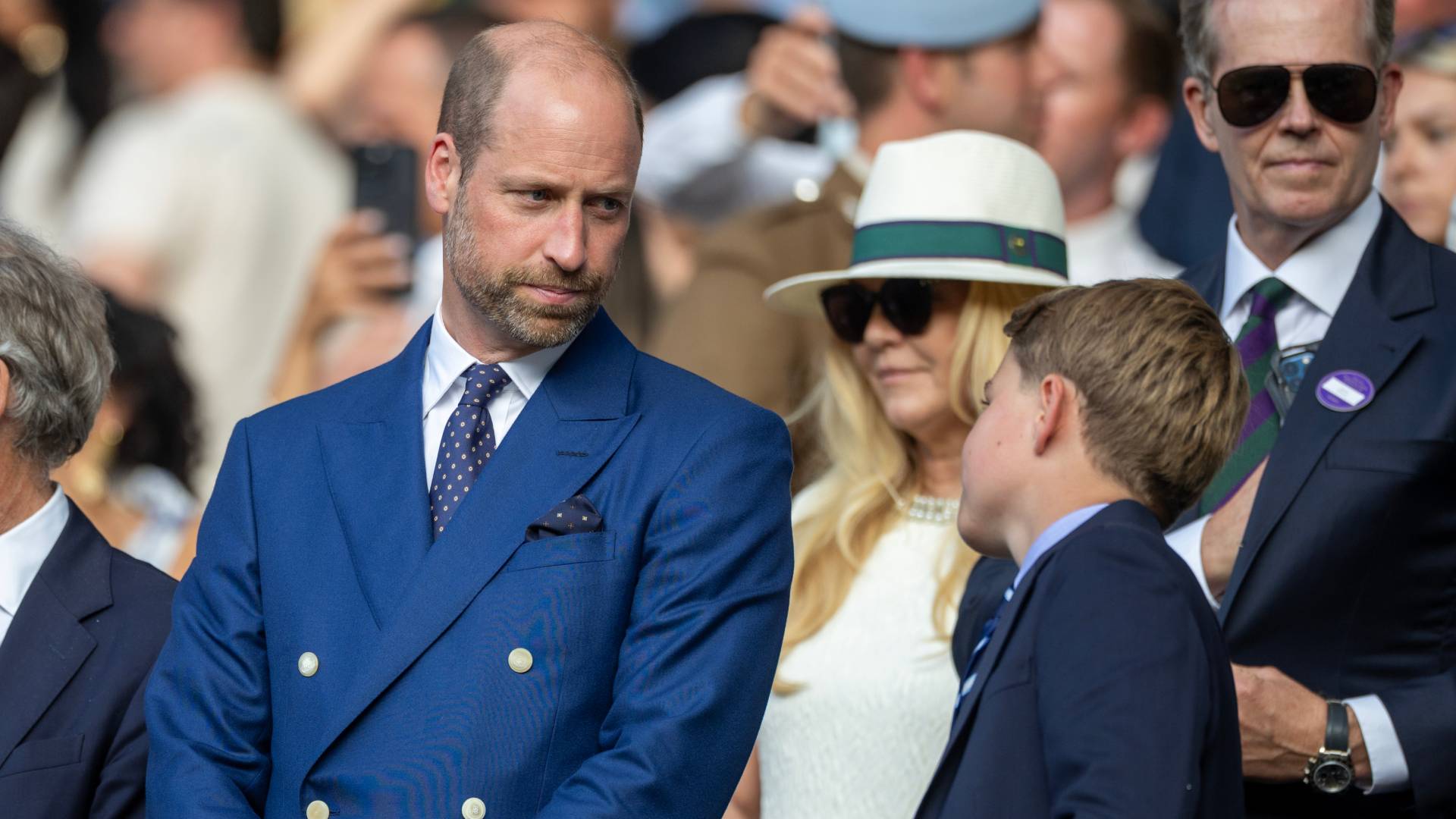 Prince George and Prince William wearing blue blazers at a Wimbledon match
