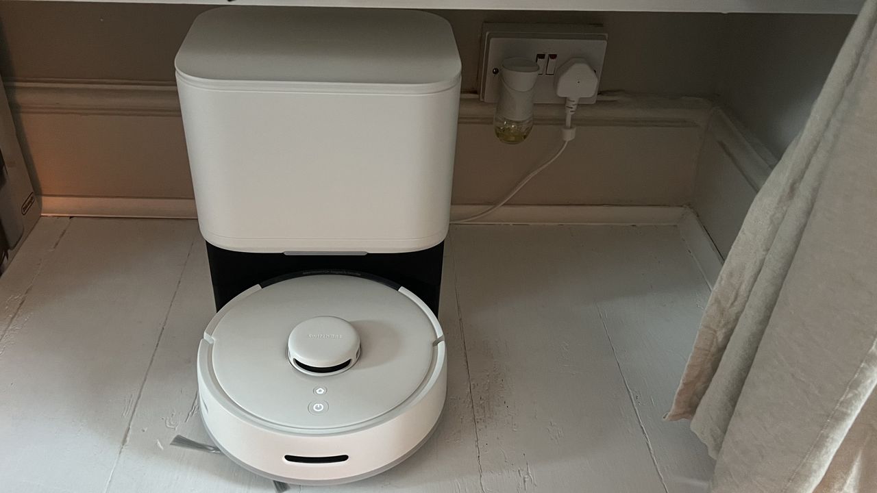 SwitchBot Mini Robot Vacuum K10+ and auto empty station plugged into wall