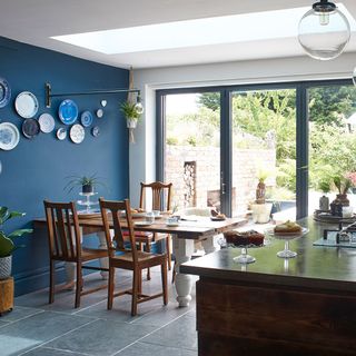 blue kitchen with dining table and hanging light
