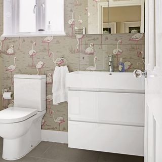 modern bathroom with flamingo wallpaper and white toilet