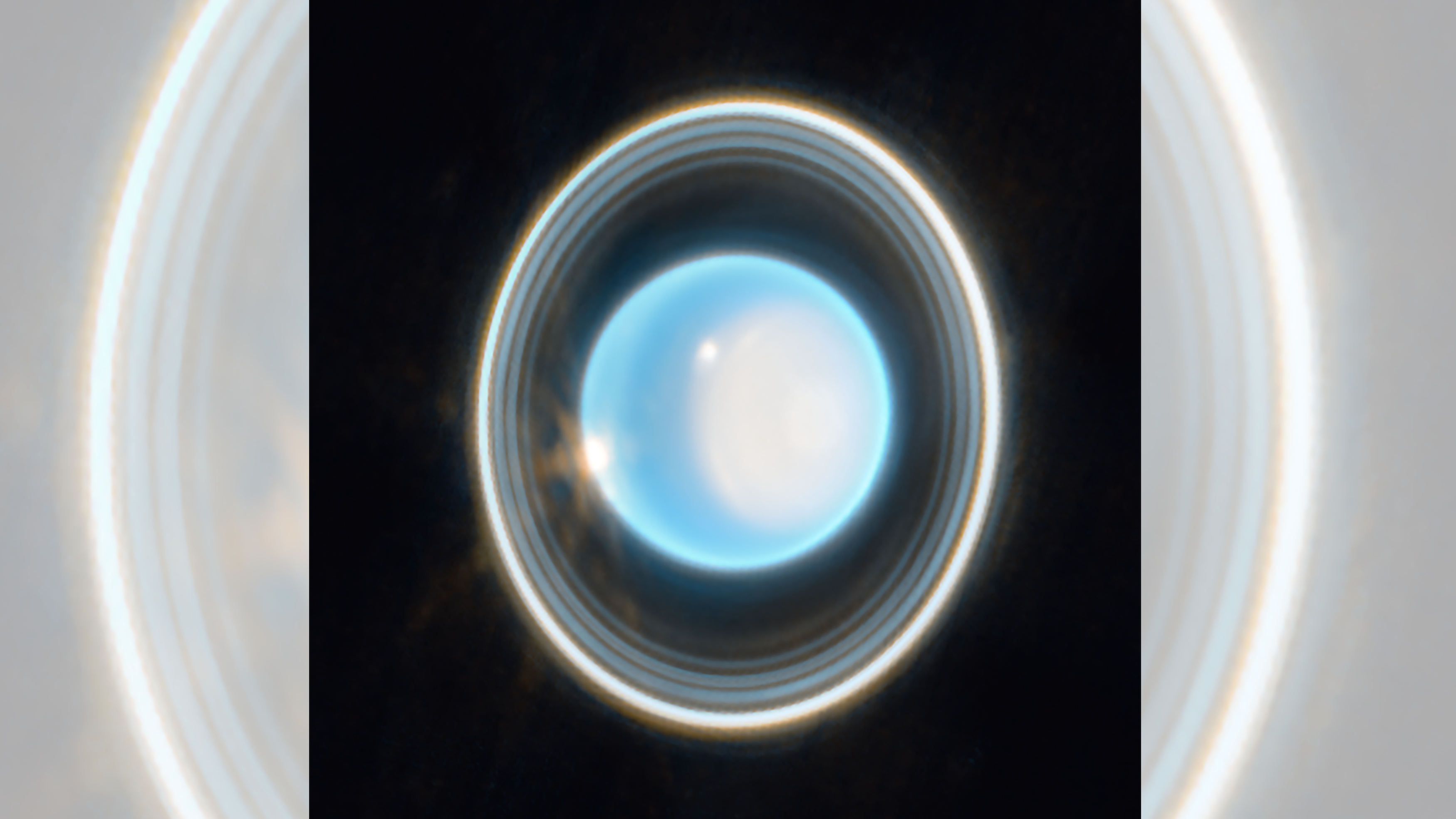 Uranus, the 7th planet from the sun, appears as a shiny blue ball surrounded by white rings in this James Webb Space Telescope image