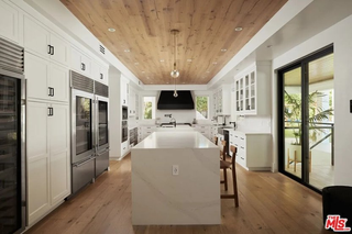A large kitchen with a wooden ceiling and a large white island