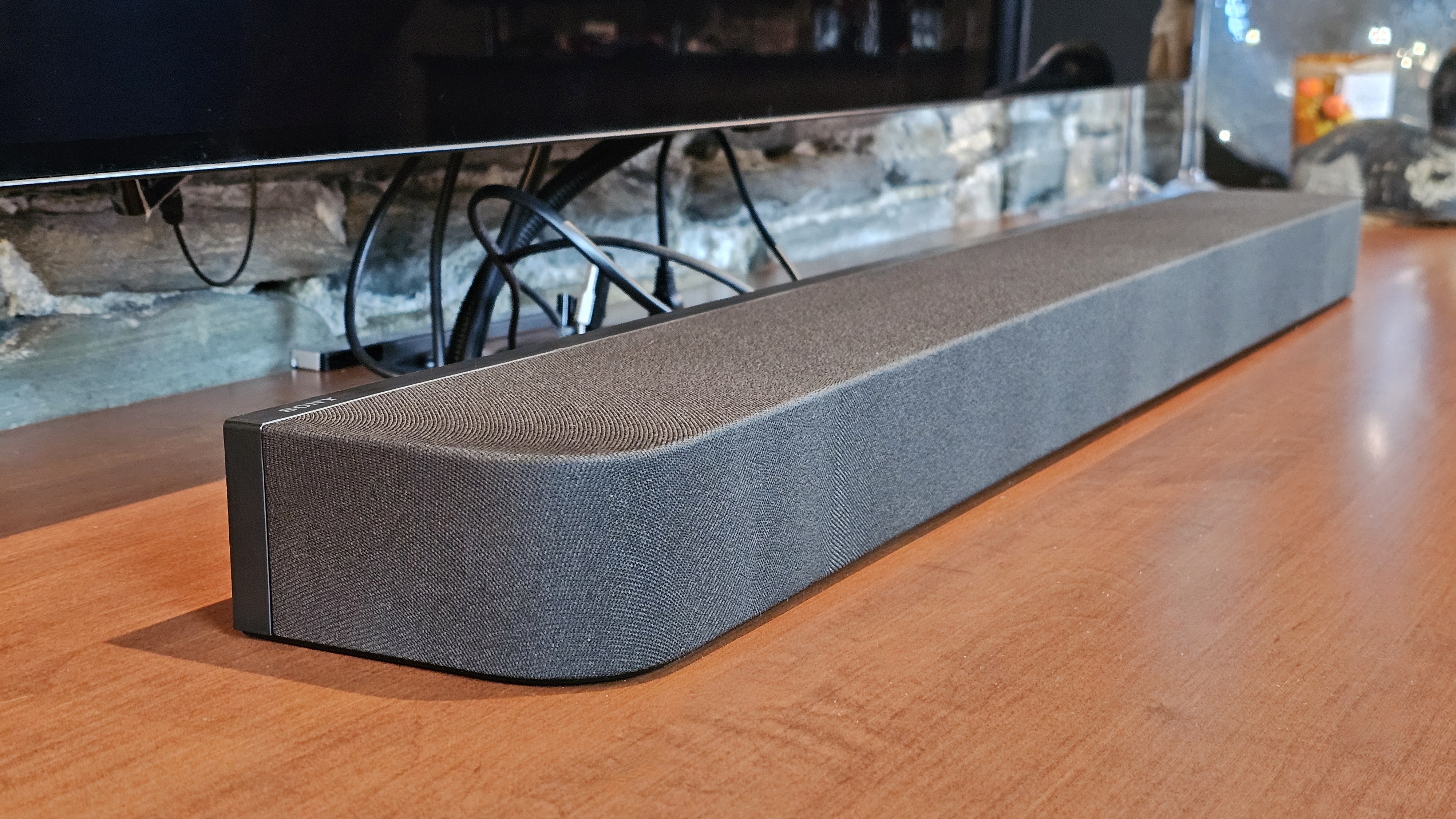 A close up of the Sony Bravia Theater Bar 7 pictured on a wooden surface under a tv