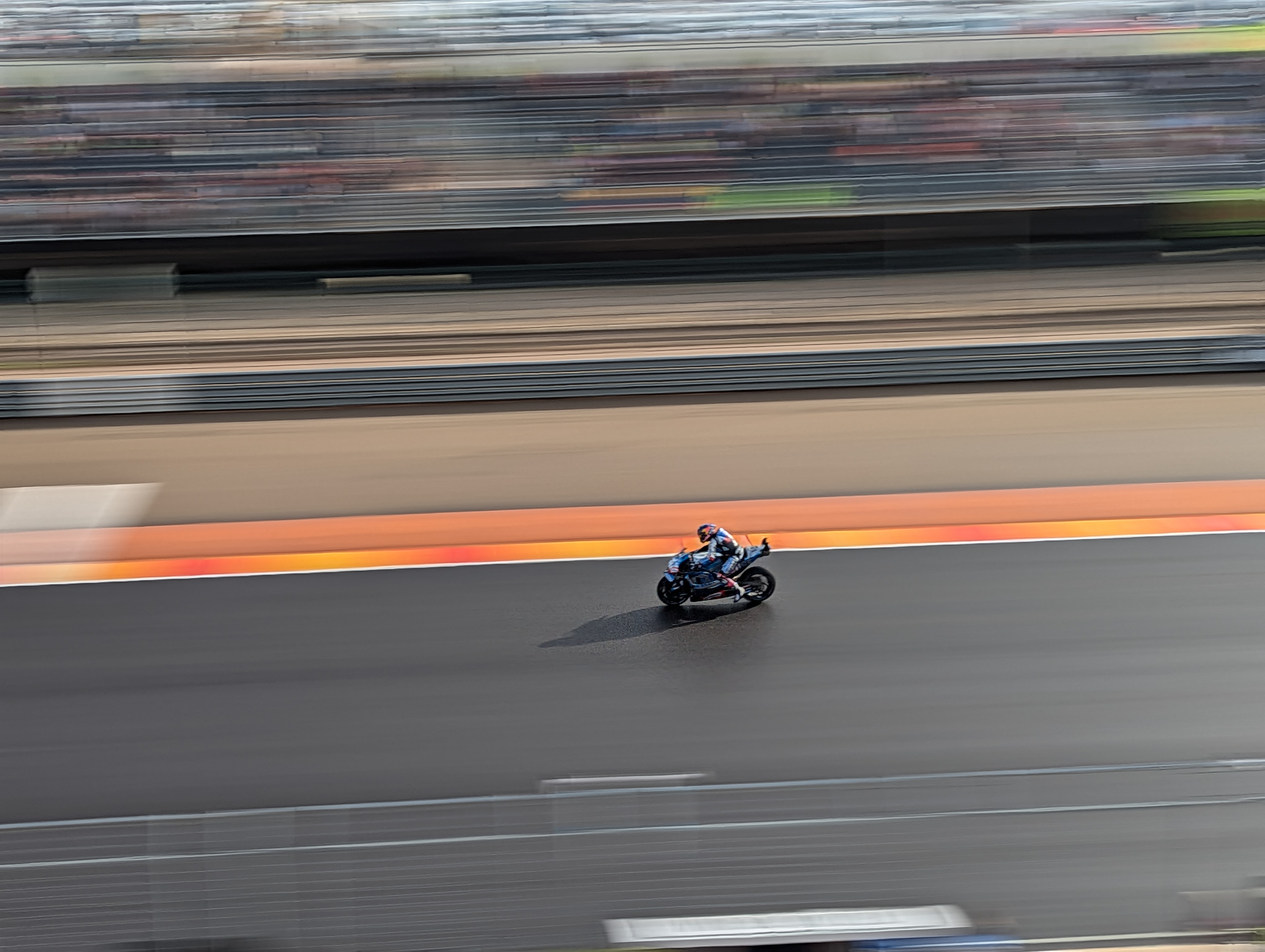 MotoGP riders at full speed on racetrack with action panning photography technique accentuating movement