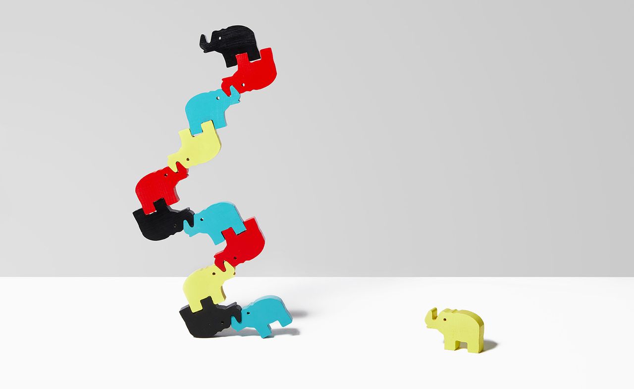 The wooden toy contains elephants in different colors stacked on each other, with one yellow elephant to the side.