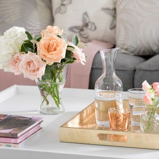 room with glass vase flower books and tray