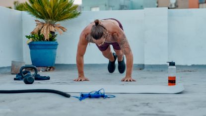 Man doing burpees on a rooftop