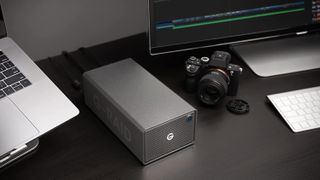 G-RAID 2 RAID Array, one of the best external hard drives for video editing, on a desk next to a camera and various computer equipment