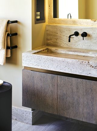 Cream bathroom with wood vanity and stone basin