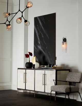 modern living room with statement pendant and matching wall light, black artwork on sideboard