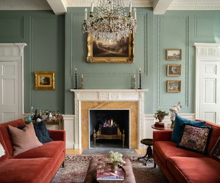 grand living room with large fireplace and pale green walls