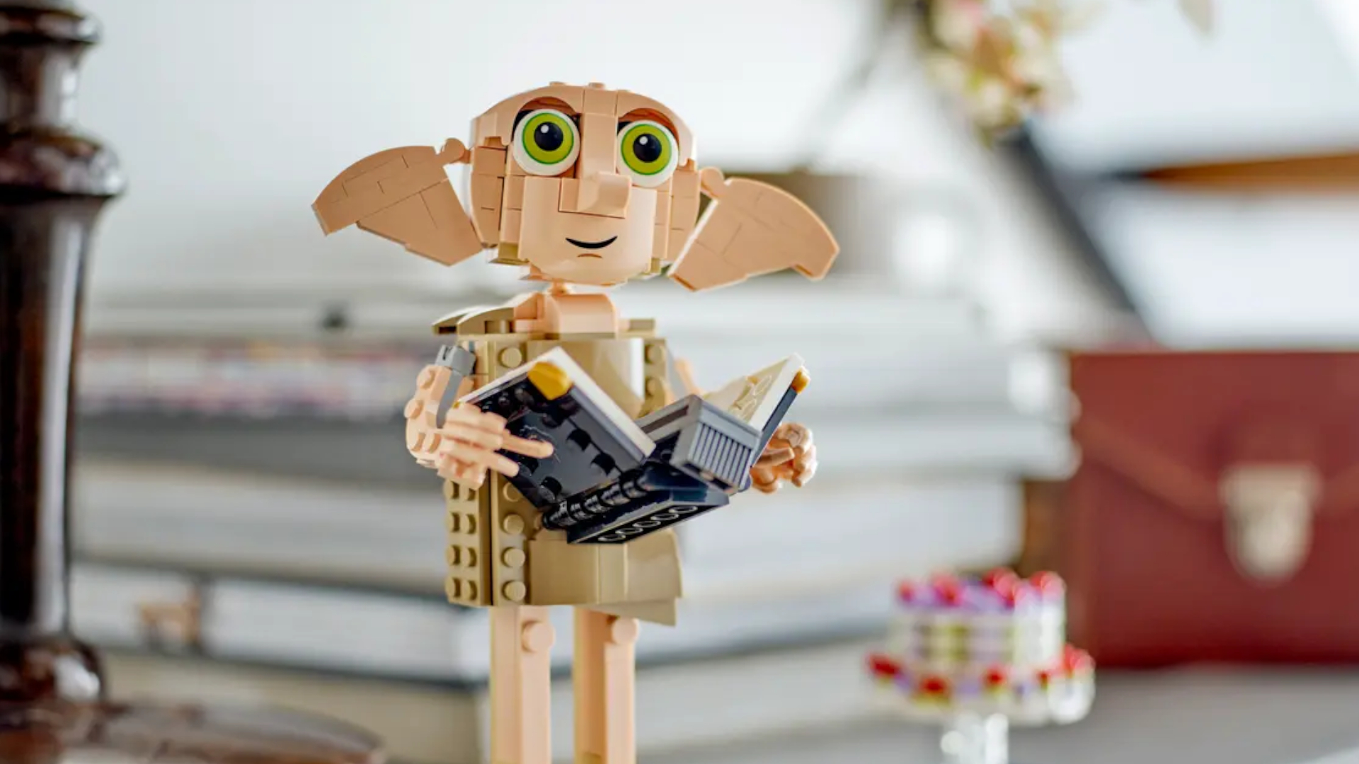 The Lego Dobby the House Elf set holding a book in a home setting