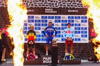 The Paris-Roubaix podium, flanked by pyrotechnics