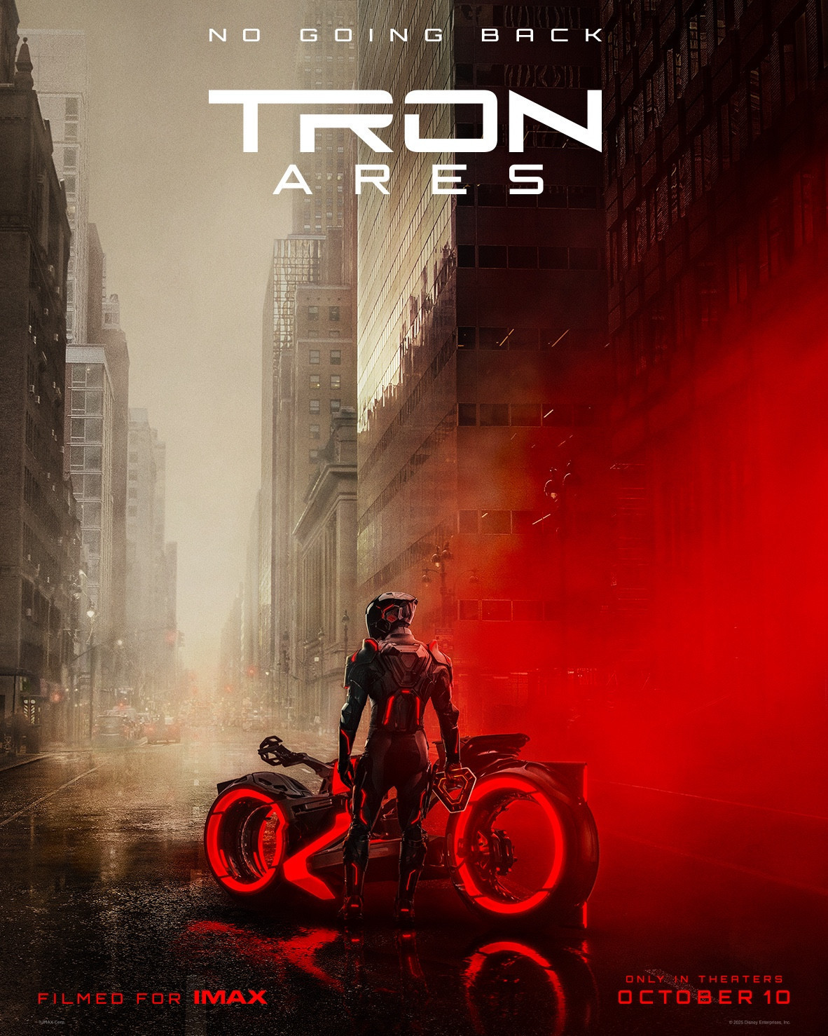 Official poster for the movie Tron: Ares. A person wearing a black bodysuit and helmet (both trimmed with red lights) is standing next to a black and red to Light Cycle (futuristic motorcycle). They are standing on a city street surrounded by tall buildings. The sky is gray and there is an ominous red light to the right that takes up about a third of the poster.