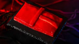 The Red Door hand pie shown plated, on a black table, in front of a red curtain from Universal Halloween Horror Nights 33.