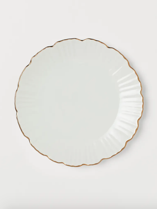 white plate with a scalloped gold rim