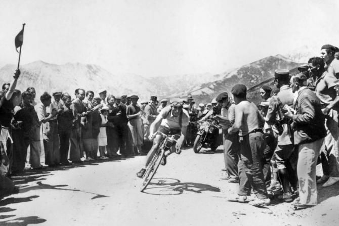 Italian Gino Bartali, cheered on by fans, negociates a curve in the Col d'Allos as he starts going downhill 22 July 1938 during the 14th stage of the Tour de France between Digne and Brian&ccedil;on. Bartali won the stage, took the yellow jersey of leader and went on to win his first Tour de France.
