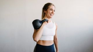 a photo of a woman in the gym holding a kettlebell