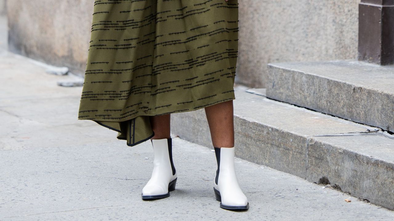 Woman in green dress and white ankle boots GettyImages-2002476646