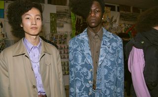 2 male models stood together wearing patterned shirts & jackets