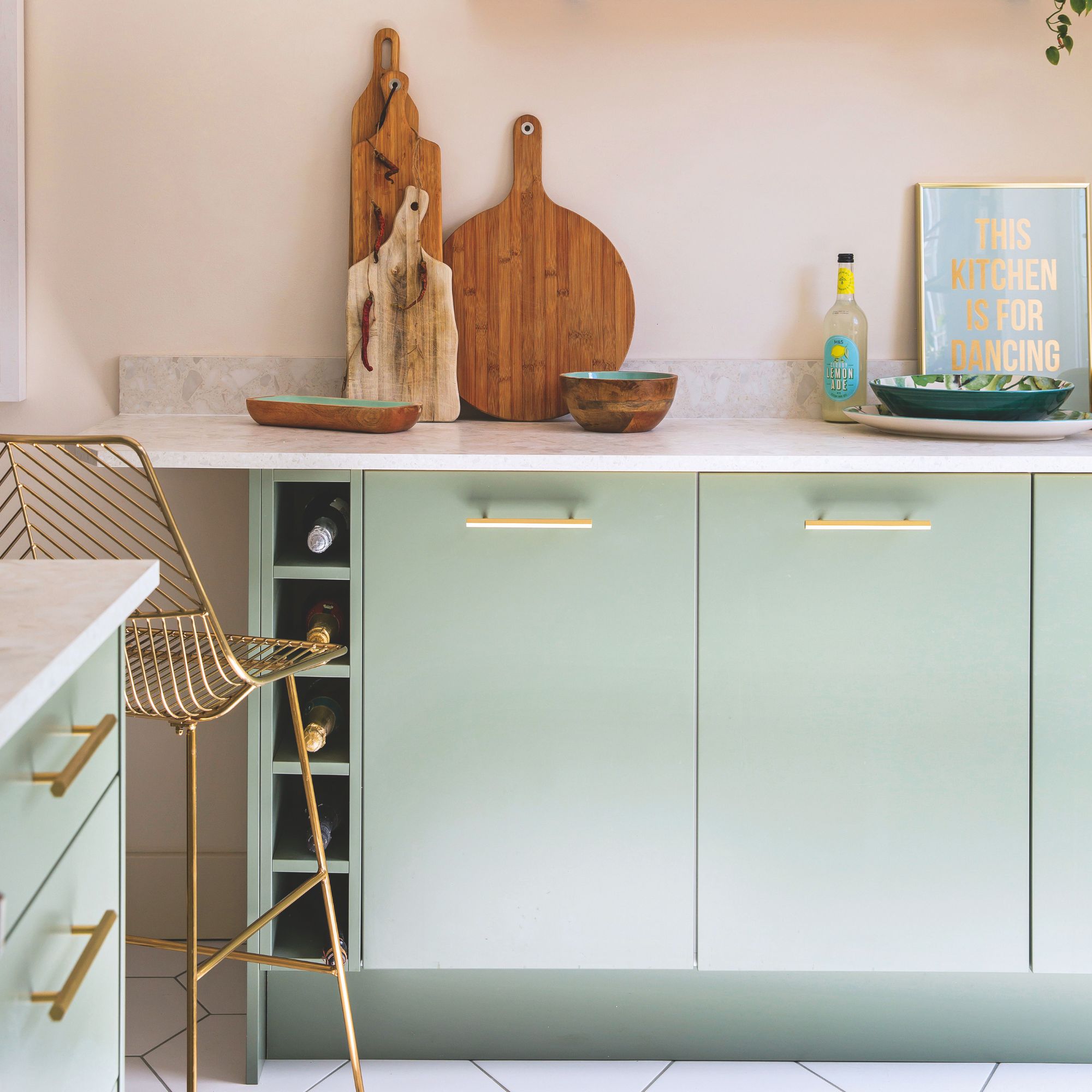 Pink painted kitchen with green cabinets and white worktops
