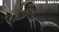 Bruce Wayne looking up at The Riddler in The Batman