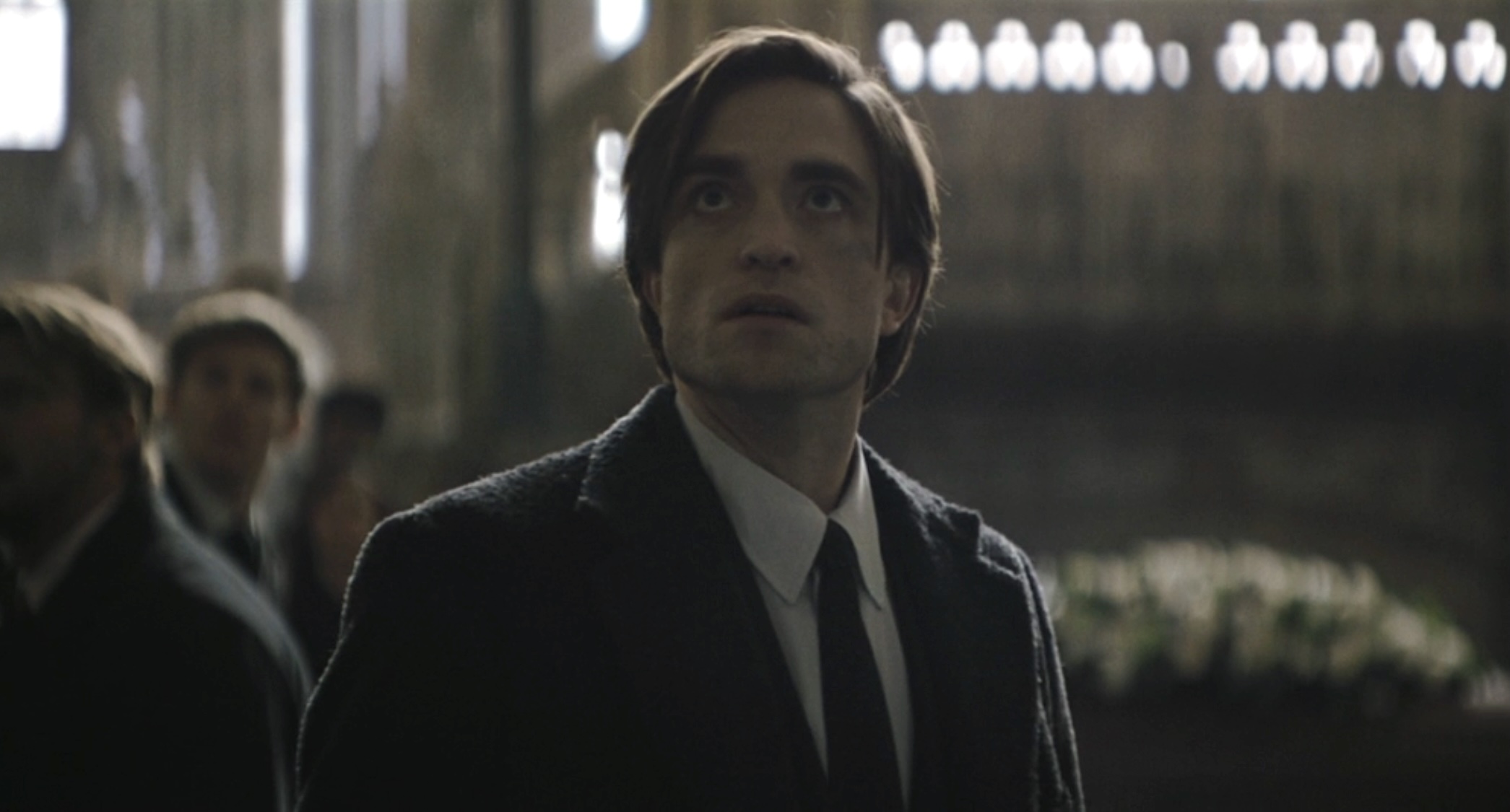 Bruce Wayne looking up at The Riddler in The Batman